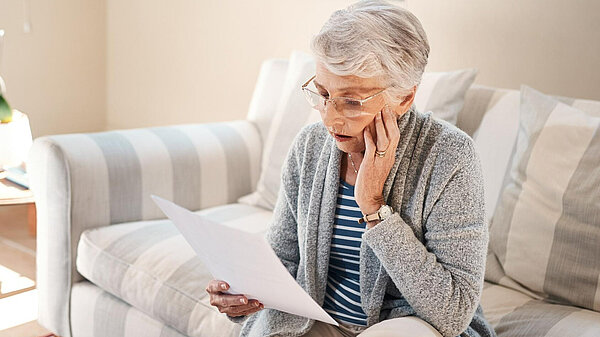 Save Winter Fuel Payments A lady looking at her bills.