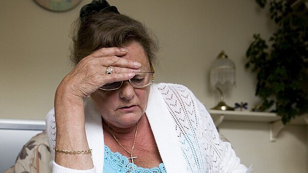 A lady looking at her bills.